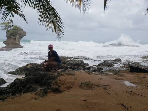 Kelli Dykstra on rocks in front of the ocean